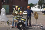 Tommy Scheel mit Leopold und David bei Checkpoint im Test des "Krachers der Woche". Wie laut ist der Aufprall von Golfb&auml;llen, die von einem Kran auf das Schlagzeug geworfen werden?