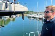 Hafenmeister Tim Fladung im Passathafen beim Kranen eines Segelbootes Hafenmeister Tim Fladung im Passathafen beim Kranen eines Segelbootes