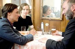 Fabian (Tom Schilling, li.) und Cornelia (Saskia Rosendahl) sitzen in ihrem Stammlokal, wo sich der arbeitslose Ray (Thomas Reimann, re.) zu ihnen gesellt. Auch das Paar muss sich bald &uuml;berlegen, wie es zu Geld kommt.