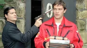 Enrico Contini (Tom Mikulla, r.) erkl&auml;rt sich bereit, die &Uuml;bergabe Plutonium gegen Diamanten durchzuf&uuml;hren. Er wird von W&ouml;rz (Fritz Karl), dem Erpresser, mit der Waffe bedroht.