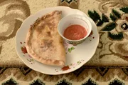 In Usbekistan werden die mit K&uuml;rbis- und Zwiebelst&uuml;cken gef&uuml;llten Teigtaschen mit Tomatensauce serviert.