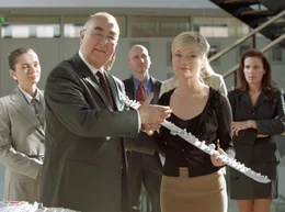 Voller Vorfreude pr&auml;sentieren Ministerialdirigent Grabow (Ludwig Haas) und Justitiarin Lena Seidel (Johanna Christine Gehlen) das Modell der geplanten Autobahntrasse.