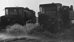 Lastwagen transportieren Menschen und G&uuml;ter &uuml;ber das bereits tauende Eis des Ladoga-Sees.