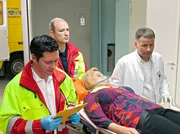 Die Kinderbuchautorin Eva Blum (Susanne Szell, liegend) wurde bewusstlos vor ihrer Haustür gefunden. Dr. Philipp Brentano (Thomas Koch, li.) und ein Sanitäter übergeben die Patientin an Dr. Roland Heilmann (Thomas Rühmann, re.). Die Kinderbuchautorin Eva Blum (Susanne Szell, liegend) wurde bewusstlos vor ihrer Haustür gefunden. Dr. Philipp Brentano (Thomas Koch, li.) und ein Sanitäter übergeben die Patientin an Dr. Roland Heilmann (Thomas Rühmann, re.).