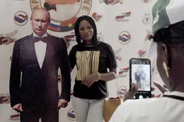 Festivalbesucher in Burkina Faso posieren mit einer Putin-Pappfigur.