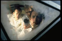 Der Mond war zu weit weg. Die M&auml;nner von Apollo 13, Fred Haise (Bill Paxton, l.), Jack Swigert (Kevin Bacon, M.) und Jim Lovell (Tom Hanks, r.), werfen vor dem Versuch, heil auf die Erde zur&uuml;ck zu kommen, einen letzten Blick auf das vergebliche Ziel ihrer Mission.