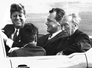 In einem offenen Wagen fahren der US-amerikanische Präsident John Fitzgerald Kennedy, der Regierende Bürgermeister von Berlin Willy Brandt und der deutsche Bundeskanzler Konrad Adenauer (l-r) durch Berlin. Höhepunkt seines Aufenthaltes bildete seine Rede vor dem Schöneberger Rathaus mit dem Satz "Ich bin ein Berliner". In einem offenen Wagen fahren der US-amerikanische Präsident John Fitzgerald Kennedy, der Regierende Bürgermeister von Berlin Willy Brandt und der deutsche Bundeskanzler Konrad Adenauer (l-r) durch Berlin. Höhepunkt seines Aufenthaltes bildete seine Rede vor dem Schöneberger Rathaus mit dem Satz "Ich bin ein Berliner".