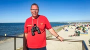 Camping am Meer! In Neuharlingersiel trennt nur der Deich den Campingplatz vom Strand. Da hat Rettungsschwimmer Dirk ordentlich zu tun. Kleine Schnittwunden durch Muscheln, Quallenstiche oder besetzte Strandk&ouml;rbe - den Ostfriesen bringt so schnell nichts aus der Ruhe.