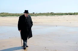 Winston Churchill (Brian Cox) denkt bei einem Spaziergang am Strand nach.