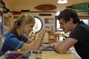 Emma (Claire Holt, li.) himmelt den Angeber Nate (Jamie Timony, re.) an. Schuld ist eine geheimnisvolle Tinktur, mit der sich Nate bespr&uuml;ht hat und die magische Anziehungskraft auf die Meerjungfrauen aus&uuml;bt.