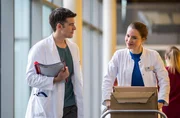 Dr. Julia Berger (Mirka Pigulla, r.) klagt ihrem Kollegen Dr. Ben Ahlbeck (Philipp Danne, l.) ihr Leid aufgrund eines widerspenstigen Kollegen. Wen kann sie meinen?