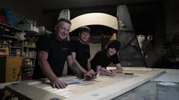 Kulissenbauer Angelo Zannin (l.) und seinen S&ouml;hne bauen das Eingangstor aus den "Jurassic Park"-Filmen nach.