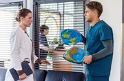 Dr. Julia Berger (Mirka Pigulla, l.) ist geschockt, als Dr. Mikko Rantala (Luan Gummich, r.) ihr sagt, dass es "Rayas Weltkugel" war, auf die sie sich versehentlich gesetzt hat. Was nun?
