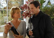 Barbara (Uschi Glas) bietet ihrem neuen Teilhaber Marius (Helmut Zierl) ein Glas Wein an.