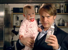 Thomas (Pierre Besson) erkl&auml;rt seinem Vater, wie hei&szlig; das Fl&auml;schchen f&uuml;r die Kleine sein darf.