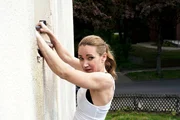 Sarah (Lisa Maria Potthoff) h&auml;ngt an der Wohnmauer zu Aidas Wohnung, um sich zu verstecken.