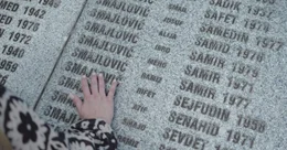 Alisa, Tochter des Schuhmachers Sejfo Sekulic, sucht nach der Inschrift ihres Vater auf einer Erinnerungstafel an die Opfer des Massakers in Srebrenica.