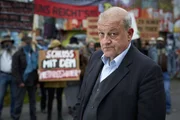 Georg Wilsberg (Leonard Lansink) unter falscher Identit&auml;t als finanzstarker Investor bei einer Demonstration der Freihafen Initiative M&uuml;nster.