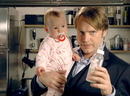 Thomas (Pierre Besson) erkl&auml;rt seinem Vater, wie hei&szlig; das Fl&auml;schchen f&uuml;r die Kleine sein darf.