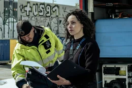 Polizeitaucherin Kiki (Marie Vinck) fragt sich, zu wem die gefundene Hand geh&ouml;rt. Neben ihr steht ein Arbeiter in Warnschutzjacke (Schauspieler unbekannt).