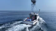 Pine Box steams out on the water with Cast on the Perch — aerial shot from behind. Pine Box steams out on the water with Cast on the Perch — aerial shot from behind.