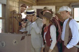 Die Filmpioniere Leo Harrigan (Ryan O'Neal, 2.v.l.), Marty Reeves (Stella Stevens, 2.v.r.) und Franklin Frank (John Ritter, re.) erhalten in Kalifornien Anweisungen von der Produktion in Chicago.