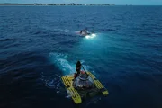 Mark Rober im roten U-Boot und Noah Schnapp im gelben U-Boot schwimmen mit einigen Mitarbeitern im Wasser Mark Rober im roten U-Boot und Noah Schnapp im gelben U-Boot schwimmen mit einigen Mitarbeitern im Wasser