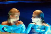 Emma (Claire Holt, li.) und Rikki (Cariba Heine) im Mondsee auf Mako Island. Sie wissen nicht, dass sie von Charlotte beobachtet werden.