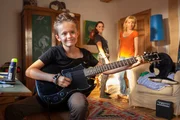 Mo (Leo Knizka, l.) rockt auf der Gitarre, Caro (Christina Gro&szlig;e, r.) entdeckt den positiven Einfluss der Metaller, die Tochter Antonia (Amelie Herres, M.) ja sowieso mag.