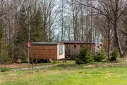 Holzwagen und Holzhaus auf dem Campingplatzgel&auml;nde "Anderswo Camp" im Bayerischen Wald.