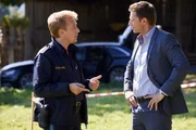 Polizeihauptmeister Mohr (Max M&uuml;ller, l.) und Kommissar Hansen (Igor Jeftic, r.) fassen am Tatort die ersten Ermittlungsergebnisse zusammen.