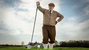 Privatdetektiv Georg Wilsberg (Leonard Lansink) beim Abschlag auf dem Golfplatz. Mit Schieberm&uuml;tze, Knickerbockern und Strickjacke, st&uuml;tzt er sich l&auml;ssig auf den Driver &ndash; fast so wie Gerd Fr&ouml;be in "James Bond &ndash; Goldfinger".