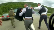 Polizisten rennen auf der Stra&szlig;e und tragen Schutzausr&uuml;stung und einen Schild.