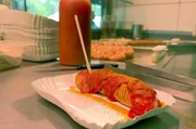 Eine gegrillte oder gekochte Wurst mit Currypulver und Tomatenso&szlig;e &ndash; die Currywurst wird in Berlin zu jeder Tages- oder Nachtzeit gegessen.