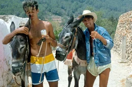 George Michael (re.) und Andrew Ridgeley (li.), besser bekannt als Popduo Wham!, besuchen die spanische Insel 1983. Sie drehen kurzerhand das Musikvideo zu ihrem Hit &bdquo;Club Tropicana&ldquo;.