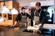 Das wird lecker! Ausbilder Manuel (l) schaut Koch-Azubi Erik auf die Finger.