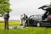 Hubert (Christian Tramitz, r.) wurde von den Bienen in die Hand gestochen. Dr. Anja Licht (Karin Thaler) versorgt die Stiche mit einer Salbe, w&auml;hrend sich Staller (Helmfried von L&uuml;ttichau, l.) ein Bild vom Unfallopfer macht.