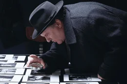 Maigret (G&eacute;rard Depardieu) sucht auf den Fotos einer Verlobungsfeier nach dem Opfer.