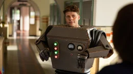 Referendar Mattes Kees (Leendert de Ridder, links) hat sich ein neues Projekt f&uuml;r seine Klasse 6b ausgedacht. Sie werden in diesem Schuljahr Roboter bauen. Stolz pr&auml;sentiert er der Direktorin, Frau Dreus (Sanne Wallis de Vries, rechts), seinen selbst kreierten Roboteranzug.
