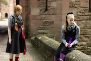 Mildred (Lydia Page, l.) ahnt, dass Esther (Jenny Richardson) ihren Reparier-Zauber mit Felicitas Hilfe verhext hat und so Frau Graustein in Scherben zerfallen hat lassen.