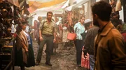 Der Abenteurer Karl (Thomas Kretschmann, l.) stellt sich dem Backpacker Yossi (Daniel Radcliffe, r.) vor, nachdem er ihm in eine Handelsgasse gefolgt ist.