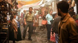 Der Abenteurer Karl (Thomas Kretschmann, l.) stellt sich dem Backpacker Yossi (Daniel Radcliffe, r.) vor, nachdem er ihm in eine Handelsgasse gefolgt ist.