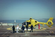 Von Polizisten umringt, wird der T&auml;ter auf dem Dach des Krankenhauses in einen Helikopter verladen.