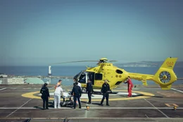 Von Polizisten umringt, wird der T&auml;ter auf dem Dach des Krankenhauses in einen Helikopter verladen.