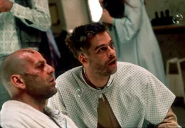In einer Irrenanstalt begegnet Cole (Bruce Willis, li.) dem hyper-hektischen Jeffrey Goines (Brad Pitt), der dem Wahnsinn nahe ist....