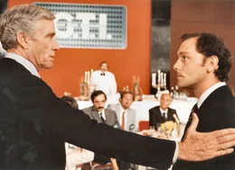 Cornelius A. Woeagen (Mel Ferrer, li.), Vorstandsvorsitzender des m&auml;chtigen multinationalen Konzerns G.T.I., beeindruckt Menschen. Der Journalist Paul Kerjean (Patrick Dewaere, re.) ist einer der wenigen, der ihm Paroli bietet.