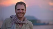 Josh Gates, host of Travel Channel's Expedition Unknown, poses in front of the setting sun in the Floating Village on the Tonle Sap. Josh Gates, host of Travel Channel's Expedition Unknown, poses in front of the setting sun in the Floating Village on the Tonle Sap.