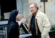 Der Produzent Alex Hoffmann (Gerd Silberbauer, r.) will Schwester Hildegards Roman als Krimiserie verfilmen. Hanna (Janina Hartwig, l.) f&uuml;hrt ihn durch das Kloster.