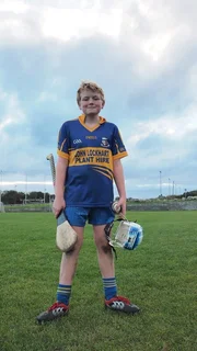 Mac mit seiner Hurling Ausrüstung: Helm, Hurl (Schläger) und Sliotar (Ball). Mac mit seiner Hurling Ausrüstung: Helm, Hurl (Schläger) und Sliotar (Ball).