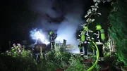 Freistaat Sachsen - Feuerwehrleute l&ouml;schten den Brand in der Gartenlaube.